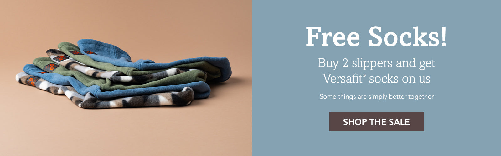 Promotional banner showing a stack of folded patterned socks on the left and sale text reading 'Free Socks! Buy 2 slippers and get Versafit socks on us' with a 'SHOP THE SALE' button on the right.