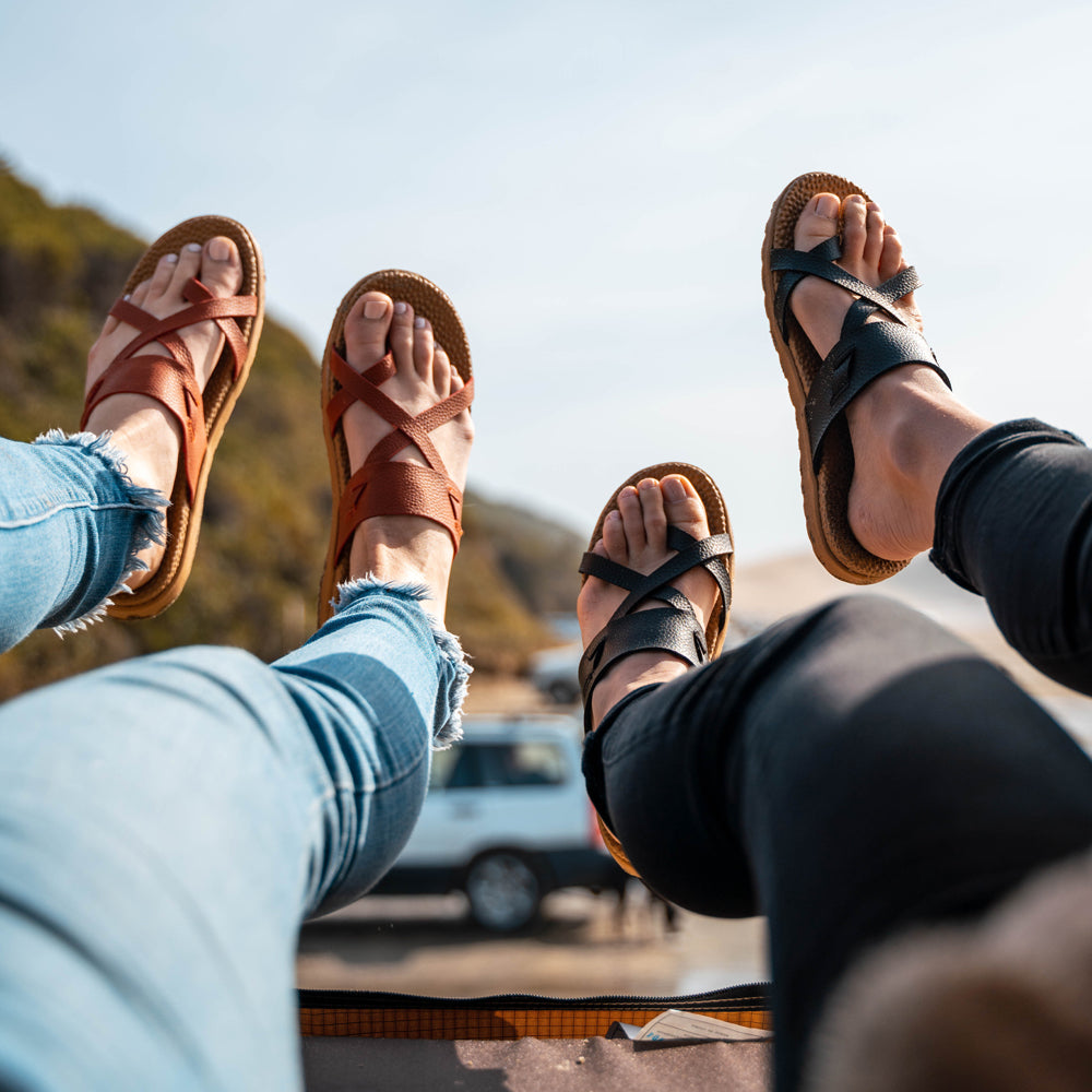 Two women both wearing the Riley Sandal in Black and Copper.